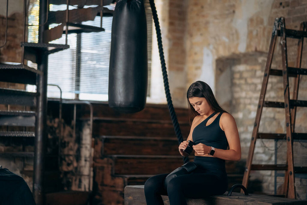 mooi jong fitness meisje zet op een bokshandschoen - Foto, afbeelding