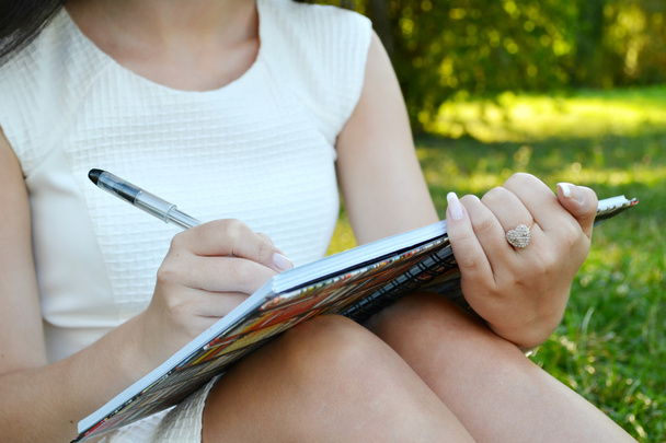 Mujer con hermosas manos escribiendo en su diario
 - Foto, Imagen