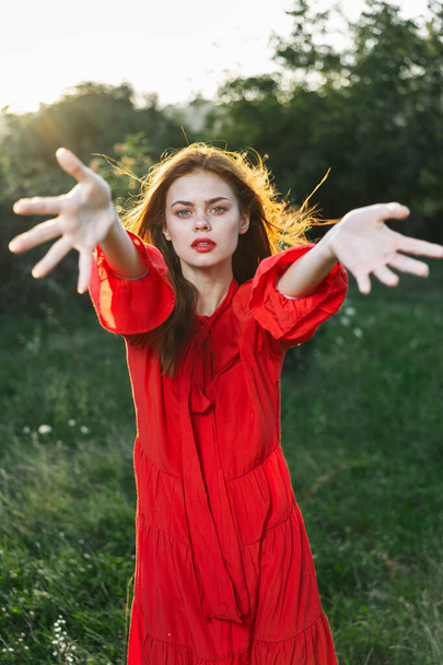 attractive woman in red dress outdoors in freedom field - Foto, imagen