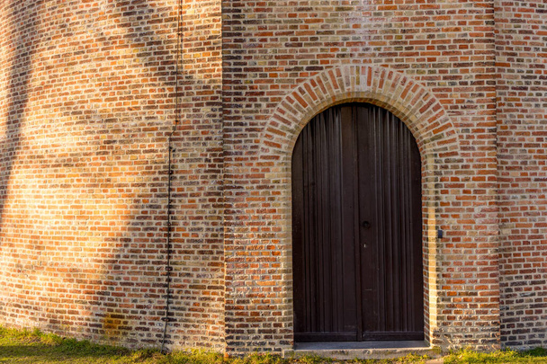 An entrance under the arch of an old brick building in Belgium, Bruges, - 写真・画像