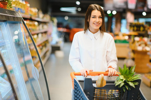 Casual woman grocery shopping and looking happy - Foto, Imagem