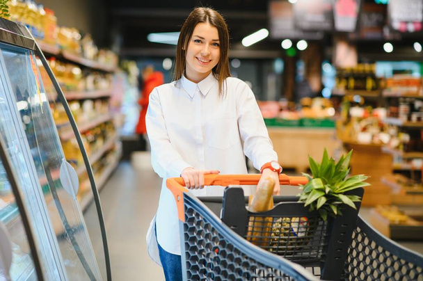 Casual woman grocery shopping and looking happy - Photo, image