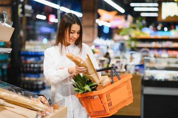 Woman holding a shopping bag of fresh food - Фото, зображення