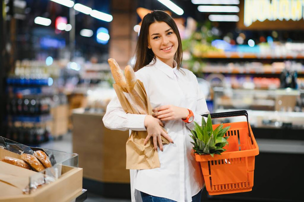 Woman grocery shopping and looking very happy - Foto, Imagen