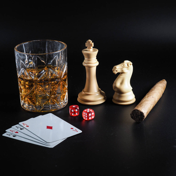 Estilo de vida de ocio con juegos de azar, juegos de azar, beber y fumar sobre fondo negro - Foto, Imagen