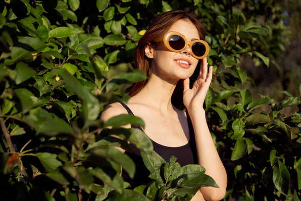 cheerful woman wearing sunglasses green leaves nature summer posing - Photo, Image