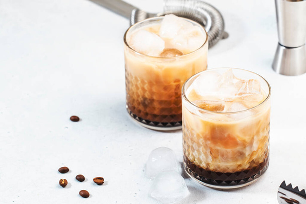 White russian cocktail, trendy alcoholic drink with vodka, coffee liqueur, cream and ice, gray background, bar tools - Zdjęcie, obraz