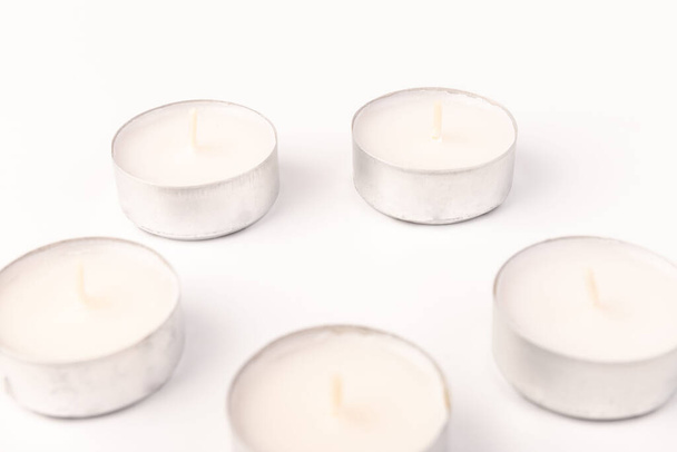White wax candles on white background. Tea light. - 写真・画像