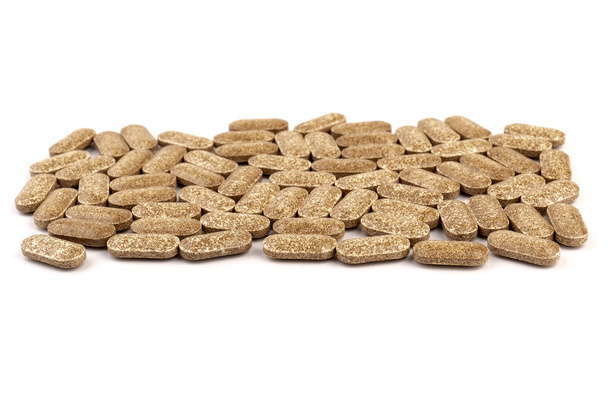 Medical, herb herbal tablets. Nutrition supplements, brown vitamin pills on white background - Photo, Image