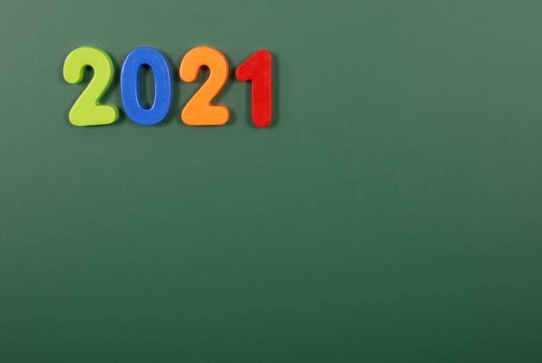 Jahr 2021 in hellen Plastikmagnetbuchstaben auf einer Magnettafel geschrieben - Foto, Bild