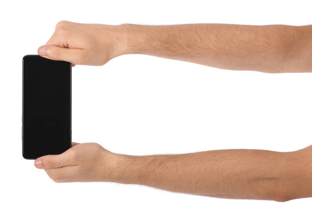 Mann hält schwarzes Smartphone mit leerem Bildschirm in der Hand. isoliert auf weißem Hintergrund. Foto in hoher Auflösung. Volle Schärfentiefe. - Foto, Bild