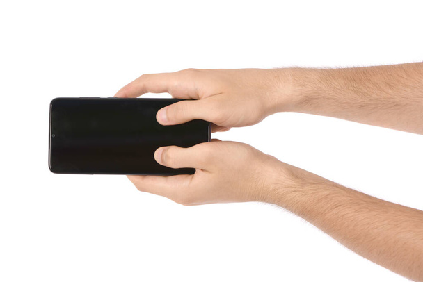 Mužská ruka držící černý smartphone s prázdnou obrazovkou. izolované na bílém pozadí. Fotka ve vysokém rozlišení. Plná hloubka pole. - Fotografie, Obrázek