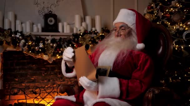 Santa Claus reading letter with list gifts from children for Christmas holidays - Footage, Video