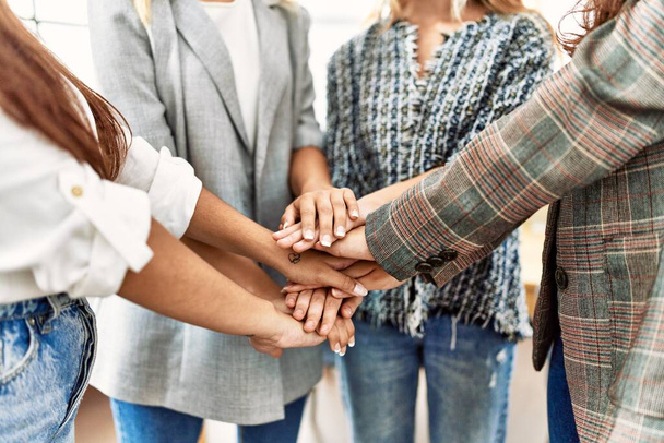 Grupo de jovem empresária de pé com as mãos juntas no escritório. - Foto, Imagem