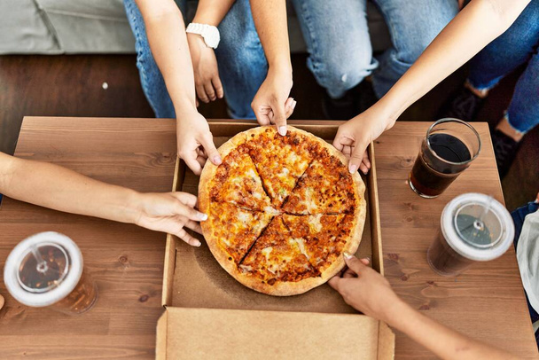 Groupe de femmes tenant une portion de pizza à la maison. - Photo, image