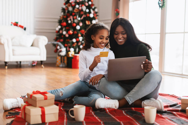 Sorrindo família negra usando pc e cartão de crédito no Xmas - Foto, Imagem
