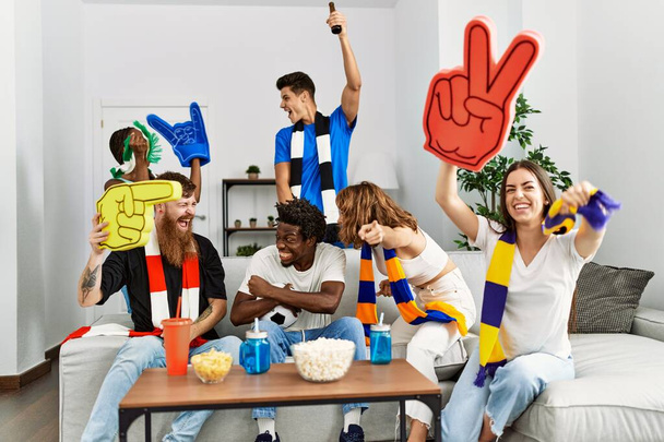Fiatal barátok csoportja nézi és támogatja a focimeccset otthon. - Fotó, kép