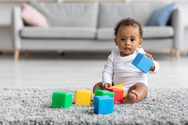 Retrato de adorável bebê infantil preto brincando com blocos de construção em casa - Foto, Imagem