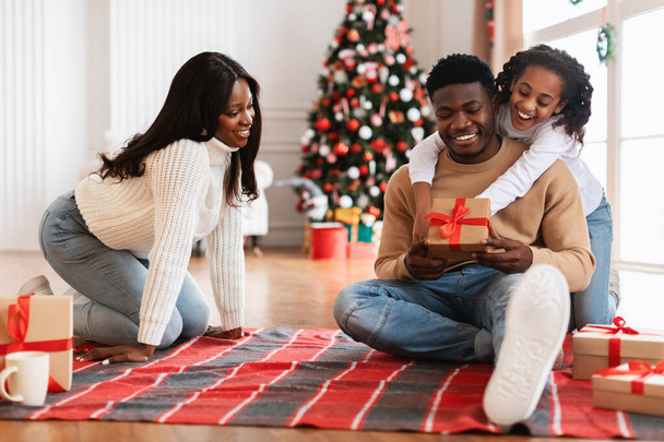 Χαρούμενη μαύρη οικογένεια γιορτάζει Χριστούγεννα ανταλλαγή δώρων - Φωτογραφία, εικόνα