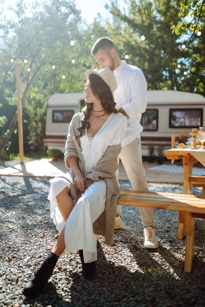 Happy newlyweds elaxing in rv, camping in a trailer. Couple embracing each other and smiling. Romantic moment. Together. Wedding. Marriage. - Фото, зображення