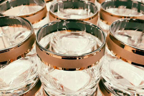 Lots of clear glass goblets. Glassware production. Empty glasses with decorative rims at the factory. Selling tableware in the store. - Photo, Image
