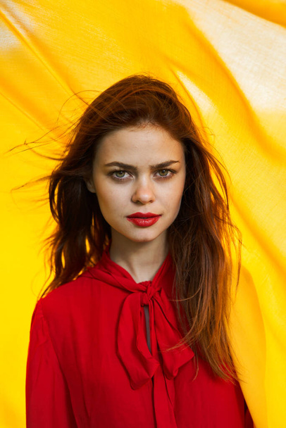 cheerful woman in red dress makeup yellow cloth posing - Foto, imagen