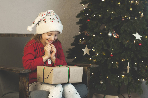 Gifts for Christmas and New Year. Children are delighted with their Christmas gifts. Under the tree. - Photo, Image