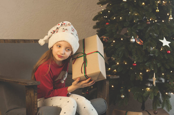 Ajándékok karácsonyra és újévre. A gyerekek el vannak ragadtatva a karácsonyi ajándékaiktól. A fa alatt.. - Fotó, kép