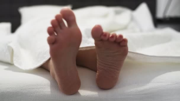 vrouw met rode pedicure schommels blote voeten liggend op bed - Video