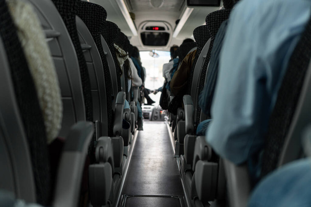 Vista di due file di sedili doppi in un autobus di viaggio con passeggeri. - Foto, immagini