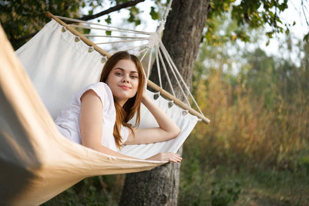 cheerful woman lies in a hammock outdoors nature vacation summer - Foto, Imagen