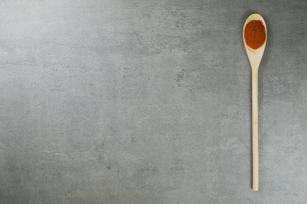 Paprika spice in wooden spoon - Фото, изображение
