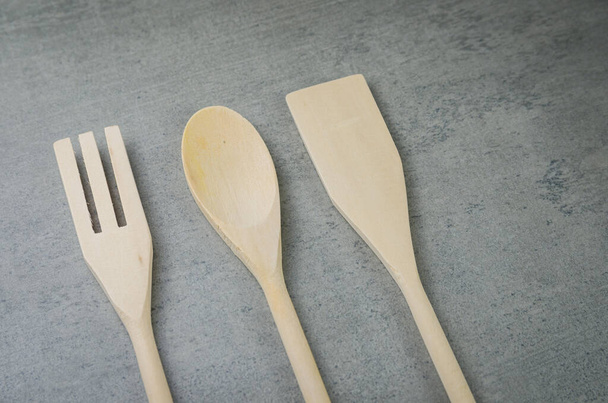 Wooden cutlery on gray background. - Фото, изображение