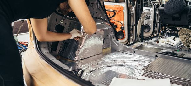 Proceso de instalación de material de insonorización al interior del coche. Auto aislamiento acústico - Foto, Imagen
