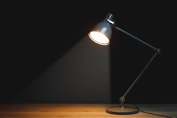 bureaulamp met schijnwerper, zwarte achtergrond met kopieerruimte - Foto, afbeelding