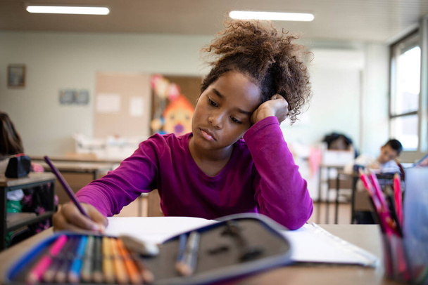 Porträt einer afroamerikanischen Schülerin, die Schwierigkeiten beim Lösen von Mathematik-Tests hat. - Foto, Bild
