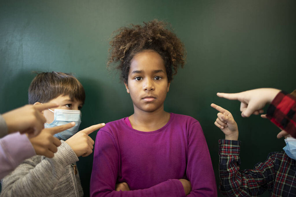 コロナウイルスパンデミックの際に顔マスクを着用しないことに対する学校児童の差別とハラスメント. - 写真・画像