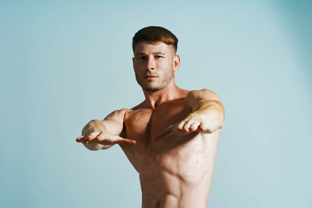 bodybuilder with muscular body posing press blue background - Fotografie, Obrázek
