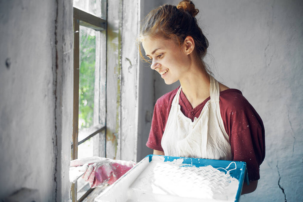 woman in apron painter repair painting window - Foto, imagen