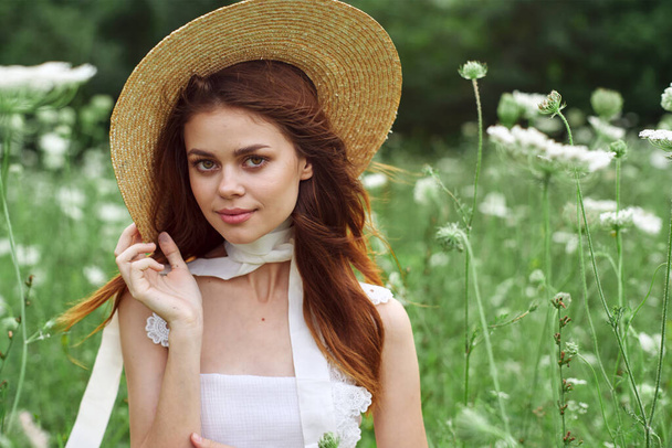 pretty woman in white dress and hat posing flowers nature - Foto, afbeelding