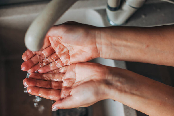 Uzavřít portrét ženské ruky, umýt si ruce pod vodou z kohoutku. Koronavirus. Pandemická situace. - Fotografie, Obrázek