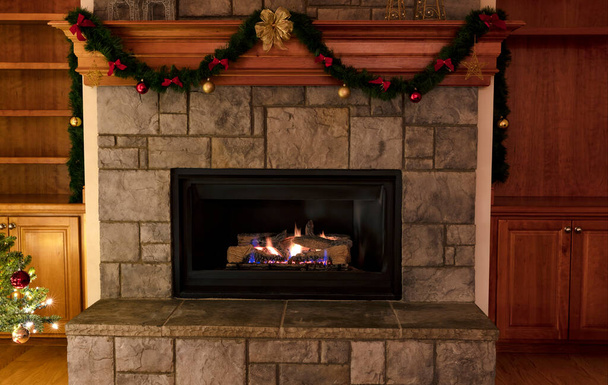 Natural gas insert fireplace, ceramic logs, decorated for a Merry Christmas or a Happy New Year concept  - Photo, Image
