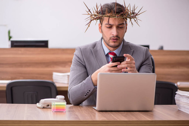 Young male employee wearing prickly wreath on head - Φωτογραφία, εικόνα
