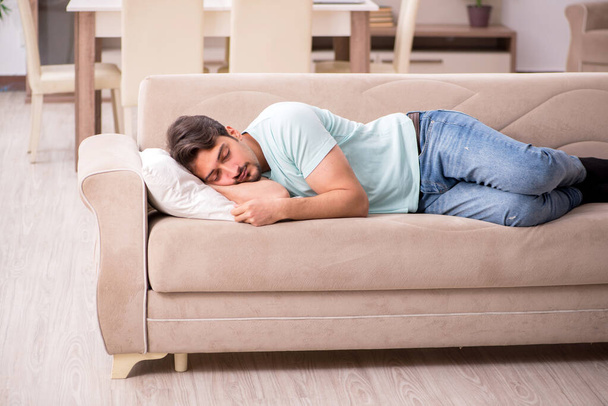 Jeune homme étudiant couché sur le canapé à la maison - Photo, image
