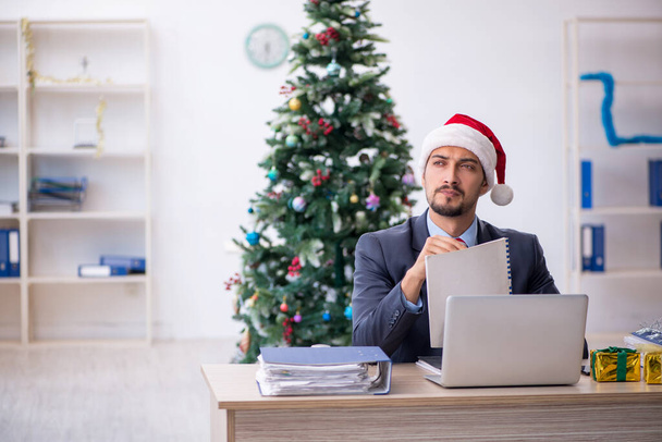 Jeune employé masculin célébrant Noël sur le lieu de travail - Photo, image