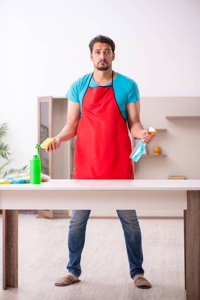 Young male contractor cleaning the house - Φωτογραφία, εικόνα