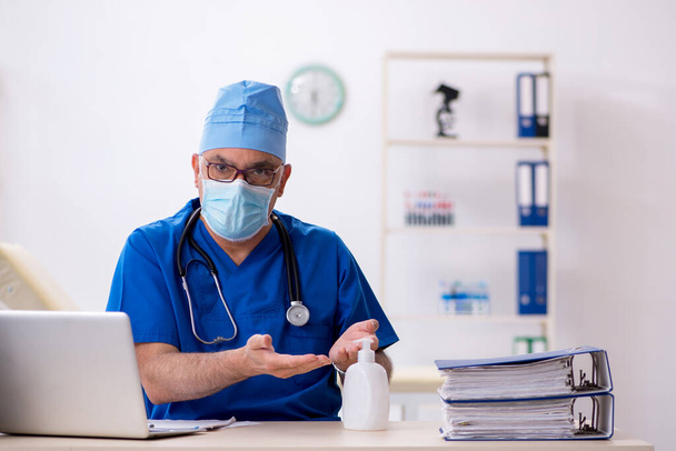 Médico do sexo masculino que trabalha na clínica durante a pandemia - Foto, Imagem