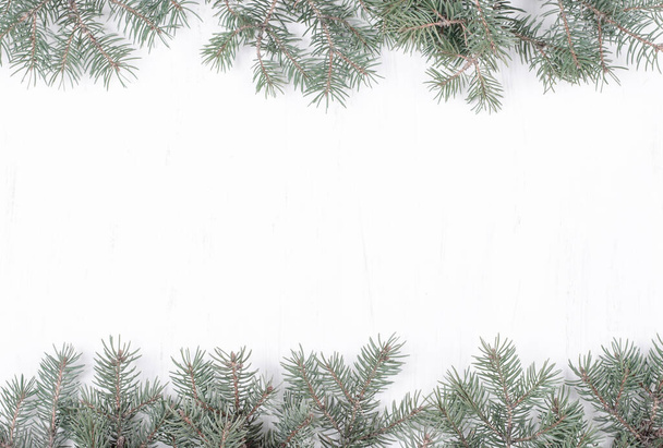 Christmas Card. Fir Branches on White Wooden Background - Photo, Image