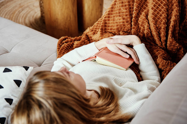 Woman sleeps on couch with book - Photo, Image
