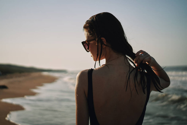 woman in black swimsuit walking on the beach ocean summer - Fotoğraf, Görsel